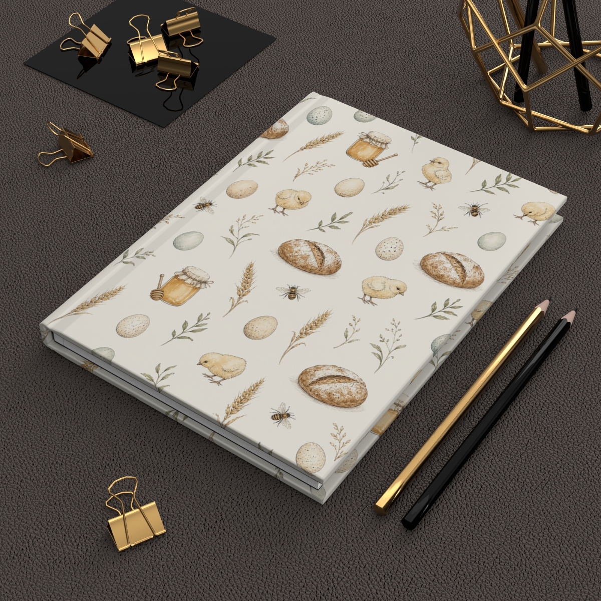 Hardcover journal with the Easter Acres farmhouse pattern beside gold stationery
